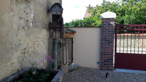 a gate in the side of a building next to a fence at Les Prés de Bondus in Chéu