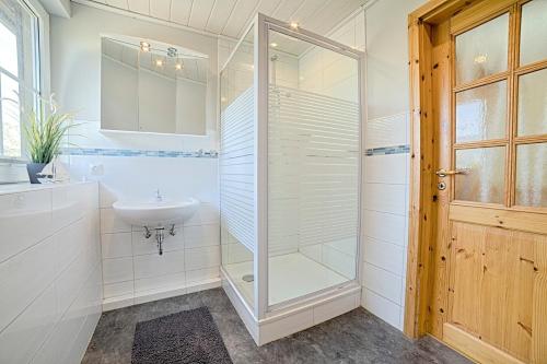 a bathroom with a glass shower and a sink at "Ferienhof Seelust" Reihenhaus 8 in Gammendorf