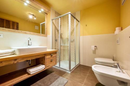 een badkamer met een wastafel, een douche en een toilet bij Zimmerhofer A4 Panorma in Cadipietra