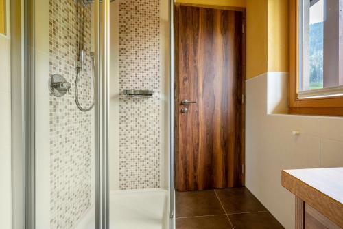 W łazience znajduje się prysznic ze szklanymi drzwiami. w obiekcie Zimmerhofer B4 Kristall w mieście Cadipietra