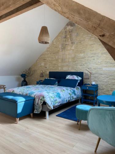 a bedroom with a blue bed and blue chairs at Charmante maison du XVIII en pierre rénovée in Colleville-Montgomery