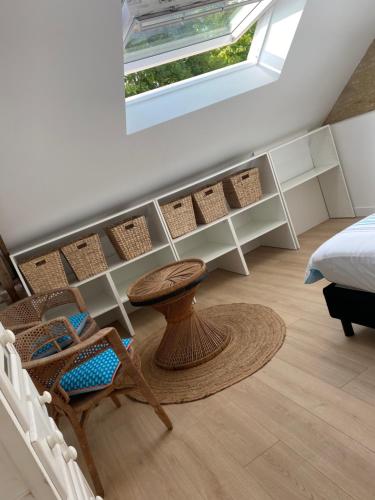 een slaapkamer met een bed en een tafel en stoelen bij Charmante maison du XVIII en pierre rénovée in Colleville-Montgomery