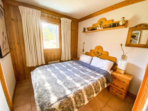 um quarto com uma cama e uma janela em SkiMottaret em Méribel
