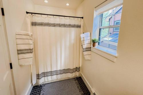 a bathroom with a shower curtain and a window at Northstar 13 in Telluride