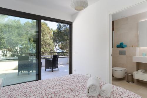a bedroom with a bed and a sliding glass door at 4 Bedroom Modern House, Llafranc, Costa Brava in Llafranc