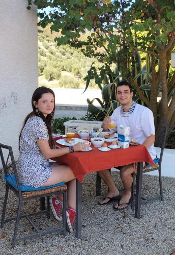 Ein Mann und eine Frau sitzen an einem Tisch in der Unterkunft Casa el Castano in Martos