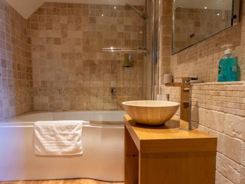 a bathroom with a bowl sink and a tub at Pass the Keys Elegant stylish home in historic town centre sleeps 3 in Moreton in Marsh