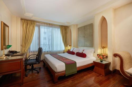 a hotel room with a bed and a desk and a computer at The Davis Bangkok in Bangkok