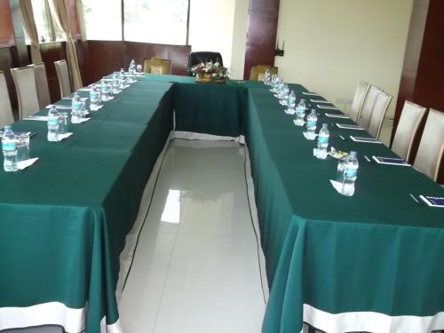 a long table with a green table cloth and glasses at Greenlight Hotel in Dar es Salaam