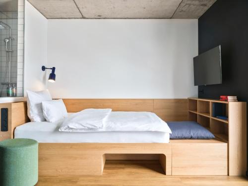 1 dormitorio con 1 cama y TV. en STAYERY Frankfurt Sachsenhausen, en Frankfurt
