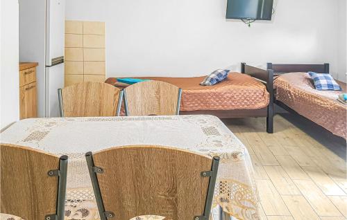 een kamer met 2 bedden en een tafel en stoelen bij Amazing Apartment In Dominikowo With Kitchen in Dominikowo