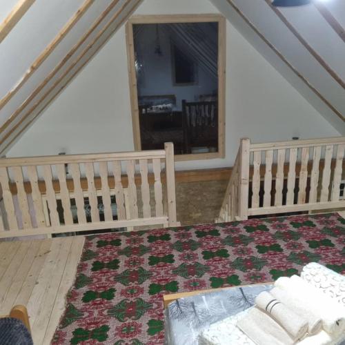 a attic room with a bed and a rug at Vikendica Jovicic in Kraljevo