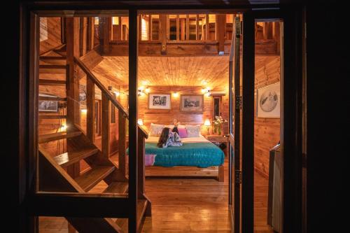 a bedroom with a bed in a wooden cabin at La Gloria Reserva Forestal in La Calera