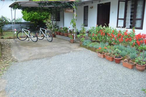 two bikes parked in front of a house with flowers at Rheinberg Town Haus in Munnar