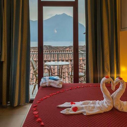 two swans making a heart on a table with a balcony at Hotel Lovere Resort & Spa in Lovere