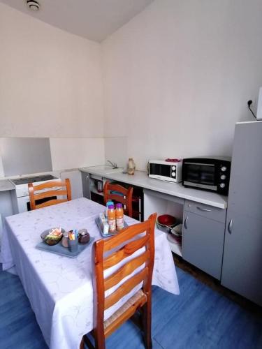 eine Küche mit einem Tisch mit einem Teller Essen drauf in der Unterkunft Bureau Lesparre-médoc, l'estuaire in Lesparre-Médoc