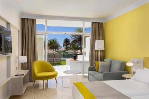 a hotel room with a bed and a living room at Abora Catarina by Lopesan Hotels in Playa del Ingles