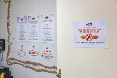 a wall with posters on the wall of a room at Aloha Hostel Pinhões in Fortaleza
