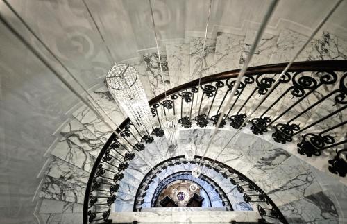 a spiral staircase with a chandelier in a building at Hotel Ziya in Podgorica