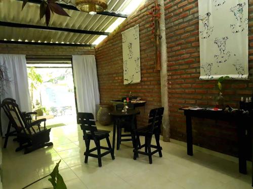 a dining room with a table and chairs and a brick wall at Gui=Neo in Minca