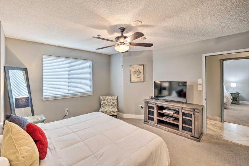 a bedroom with a bed and a flat screen tv at Shop and Dine Fort Worth Condo with Racetrack Views! in Fort Worth