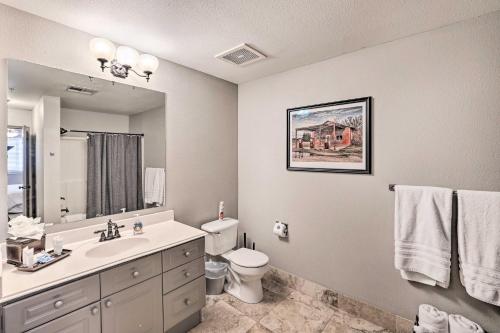 a bathroom with a sink and a toilet and a mirror at Shop and Dine Fort Worth Condo with Racetrack Views! in Fort Worth