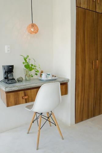 a white chair in a kitchen with a counter at Saak Luúm Ruta Puuc in Sacalum