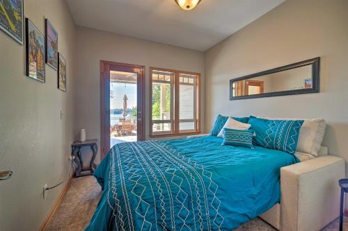 a bedroom with a bed with a blue comforter and a mirror at Spacious Lake Stevens Home with Fire Pit, Patio in Lake Stevens