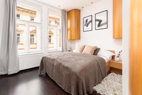 プラハにあるStylish apartment at Žižkovのベッドルーム1室(ベッド1台、大きな窓付)