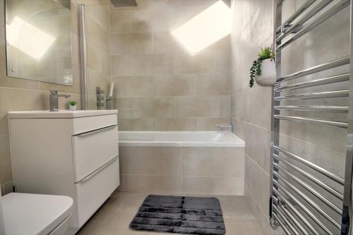 ein Badezimmer mit einer Badewanne, einem WC und einem Waschbecken in der Unterkunft Comfy 2BR/2BTH APT in Central Reading w/ Parking in Reading