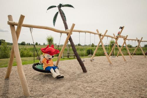 ein ausgestopftes Tier auf einer Schaukel auf einem Spielplatz in der Unterkunft Familien Wellness Hotel Seeklause mit großem Abenteuerspielplatz "Piraten-Insel-Usedom" Kinder immer All-Inklusive & Getränke ganztags inklusive in Trassenheide