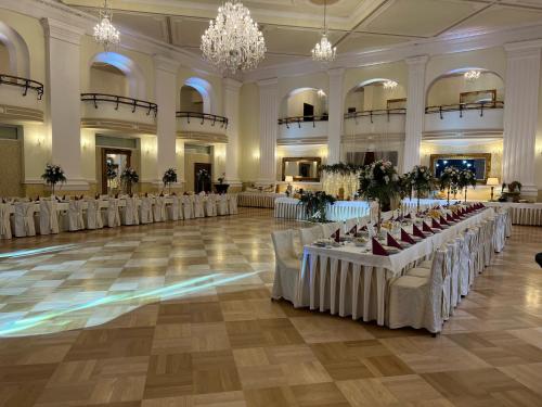 ルダ・シロンスカにあるHotel Adriaのテーブルと椅子が並ぶ宴会場