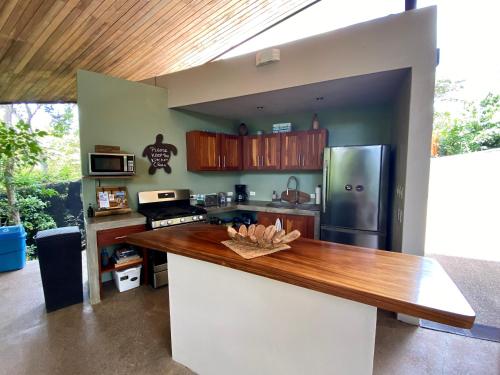 a kitchen with a wooden counter top and a refrigerator at Villas Kalei in Playa Grande