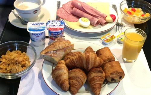 einen Tisch mit Speisen zum Frühstück und Getränken in der Unterkunft Hotel Royal Phare in Paris