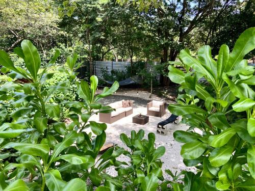 a garden with a couch and chairs and trees at Villas Kalei in Playa Grande