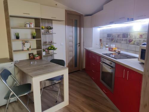 a kitchen with red cabinets and a wooden counter top at Zen Studio Slatina in Slatina