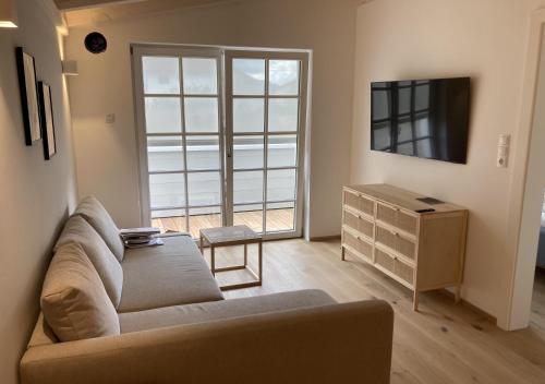 a living room with a couch and a tv and a dresser at Ferienwohnung Schauplats in Innsbruck