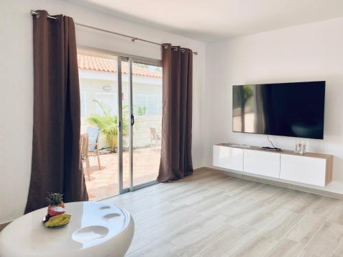 a living room with a tv and a large window at Villa Julia Relax Dream Holiday in Callao Salvaje