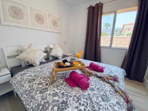 Un dormitorio con una cama con una bandeja de comida. en Villa Julia Relax Dream Holiday, en Callao Salvaje