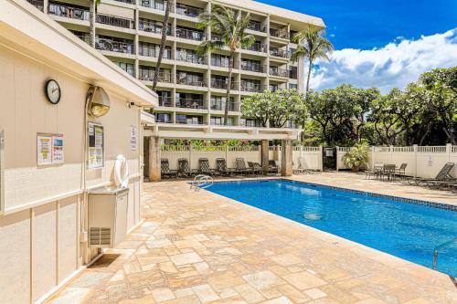 a swimming pool in front of a large building at Kihei Akahi in Wailea
