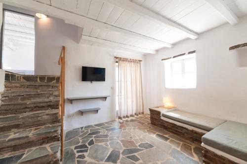 Soros Beach Antiparos في Agios Georgios: غرفة معيشة مع أريكة وتلفزيون