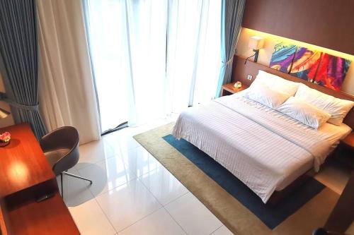 Bukit Bintang at Tribeca Residence في كوالالمبور: غرفة نوم بسرير ابيض ونافذة كبيرة