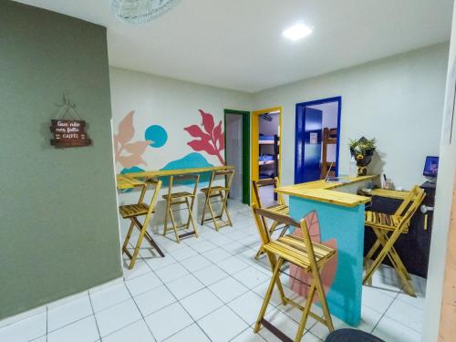 a room with tables and stools in a room at Aloha Hostel Pinhões in Fortaleza