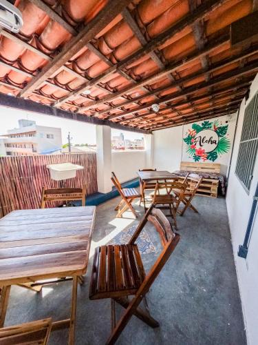 a group of tables and chairs in a room at Aloha Hostel Pinhões in Fortaleza