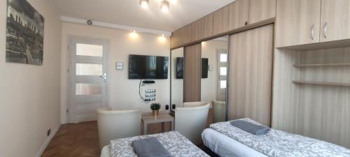 una camera con due letti e una televisione di Labo Apartment Platynowa a Varsavia