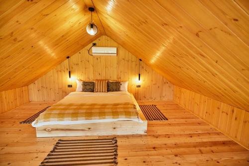 a bedroom with a bed in a wooden cabin at Scandinave Chalet Bran in Zărneşti