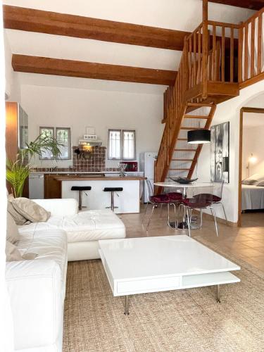 un salon avec un canapé blanc et une table dans l'établissement Maisonnette Antelissa à 3 minutes en voiture des plages et du centre ville, à Saint-Tropez