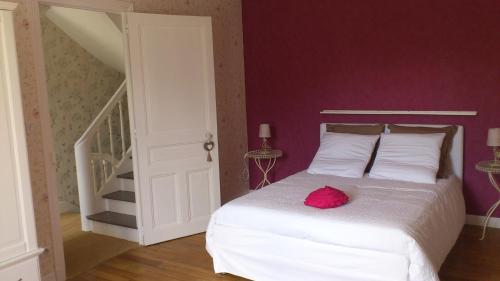 Un dormitorio con una cama blanca con una flor rosa. en La Maison des Renaudières, en Azay-le-Rideau