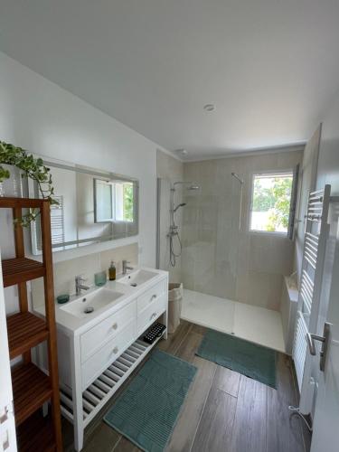 bagno bianco con doccia e lavandino di Maison 300m de l’océan, 4 a 6 personnes a Mimizan