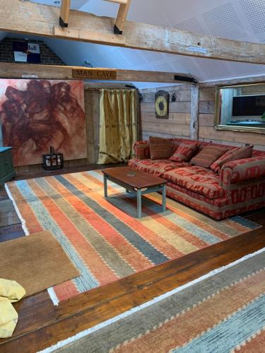 a living room with a couch and a table at Quirky Barn Conversion Crowhurst Battle in Crowhurst